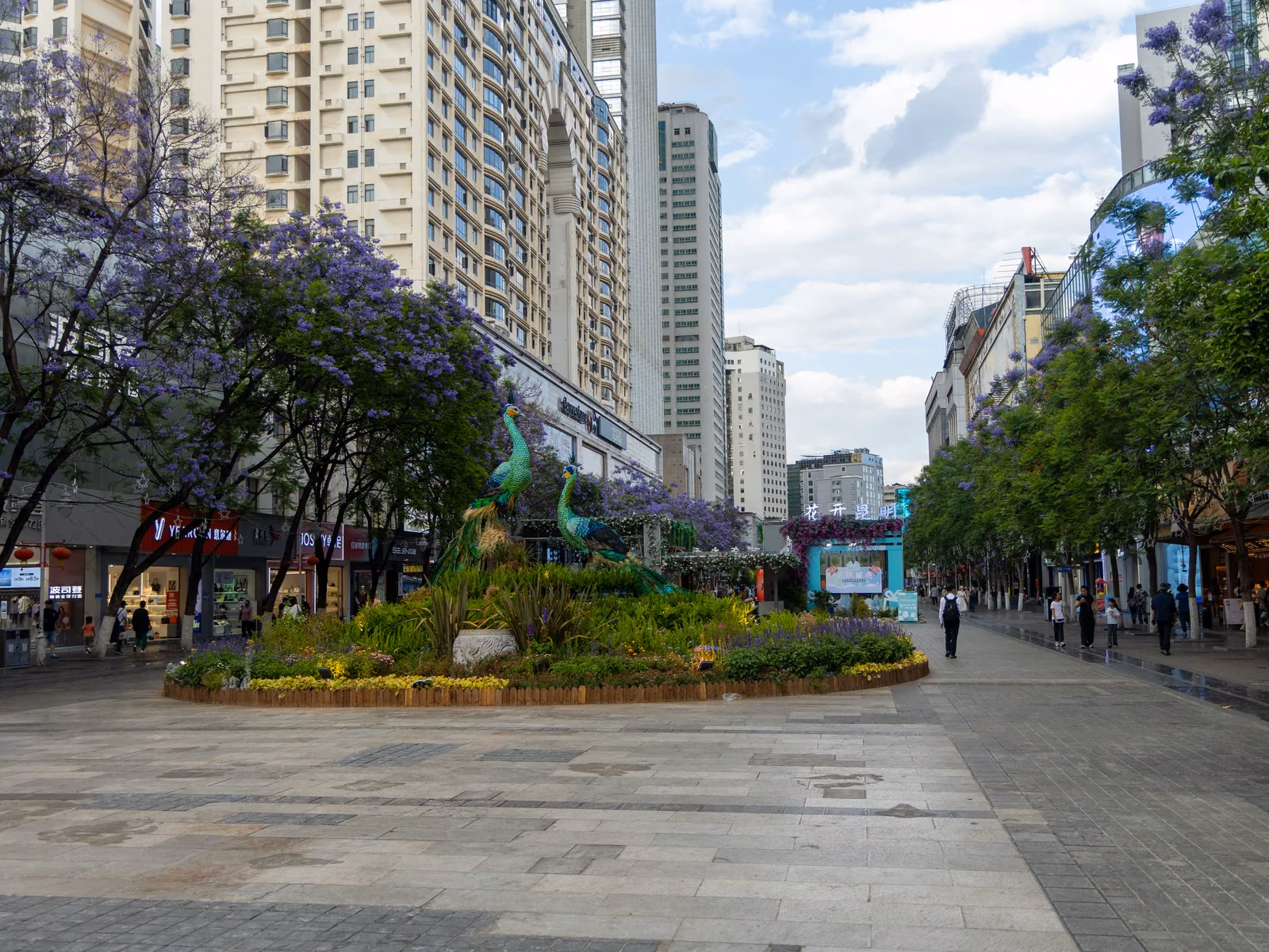 Flower beds, peacock sculptures and shops on Nanping pedestrian street in central Kunming