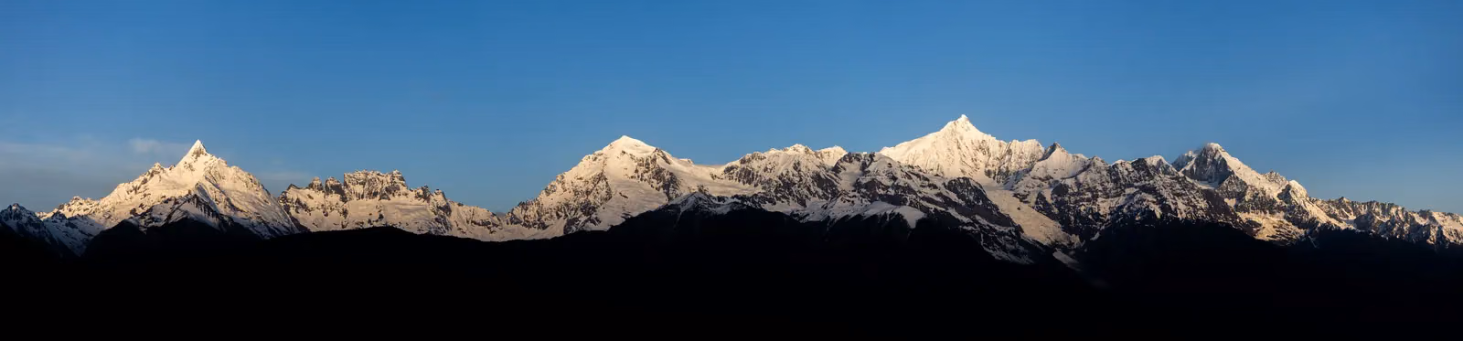 Die schneebedeckten Meili-Gipfel im Morgenlicht, gesehen von Feilaisi im Mai 2025
