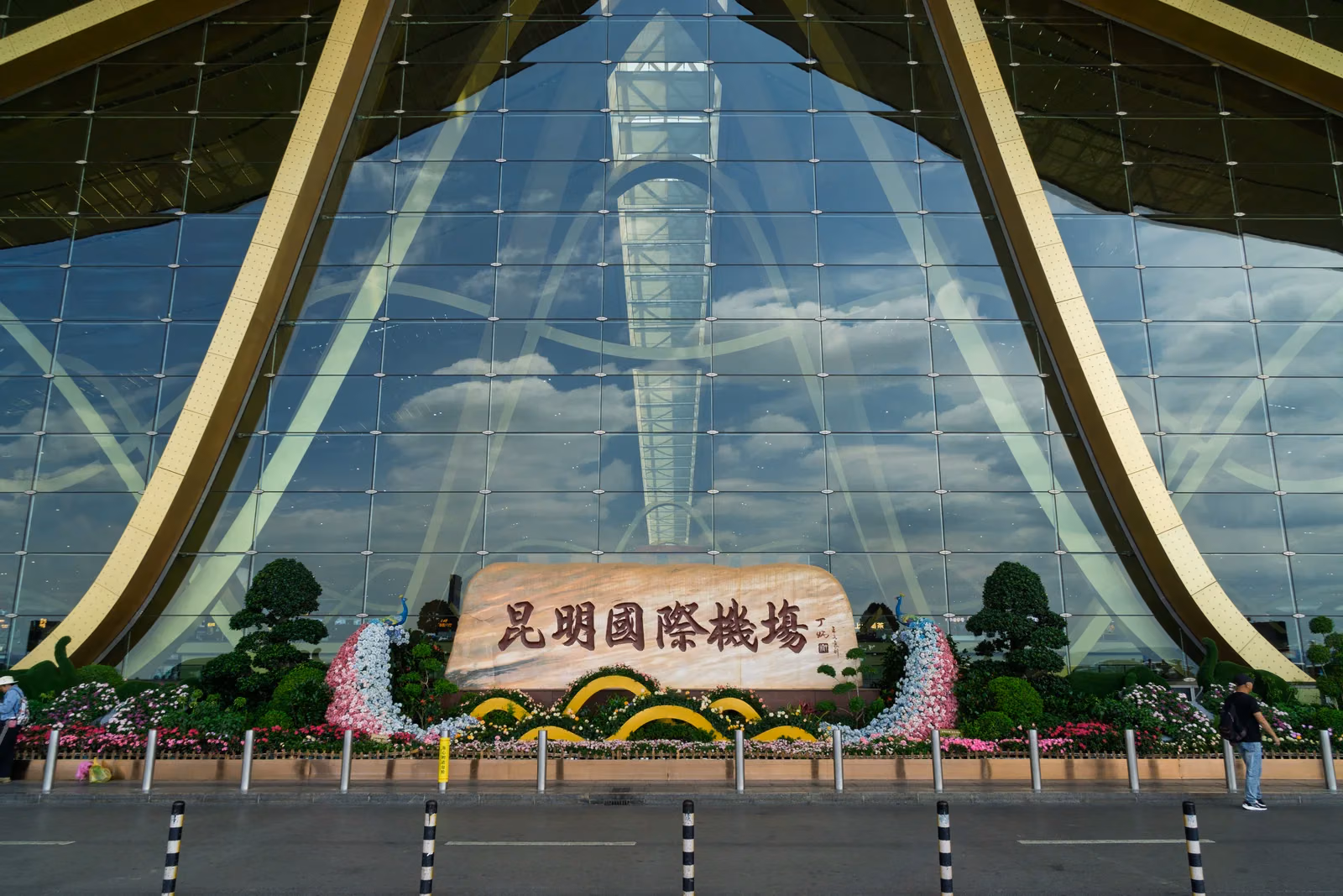 Glass facade and stone airport sign at Terminal 1 of Kunming Changshui International Airport