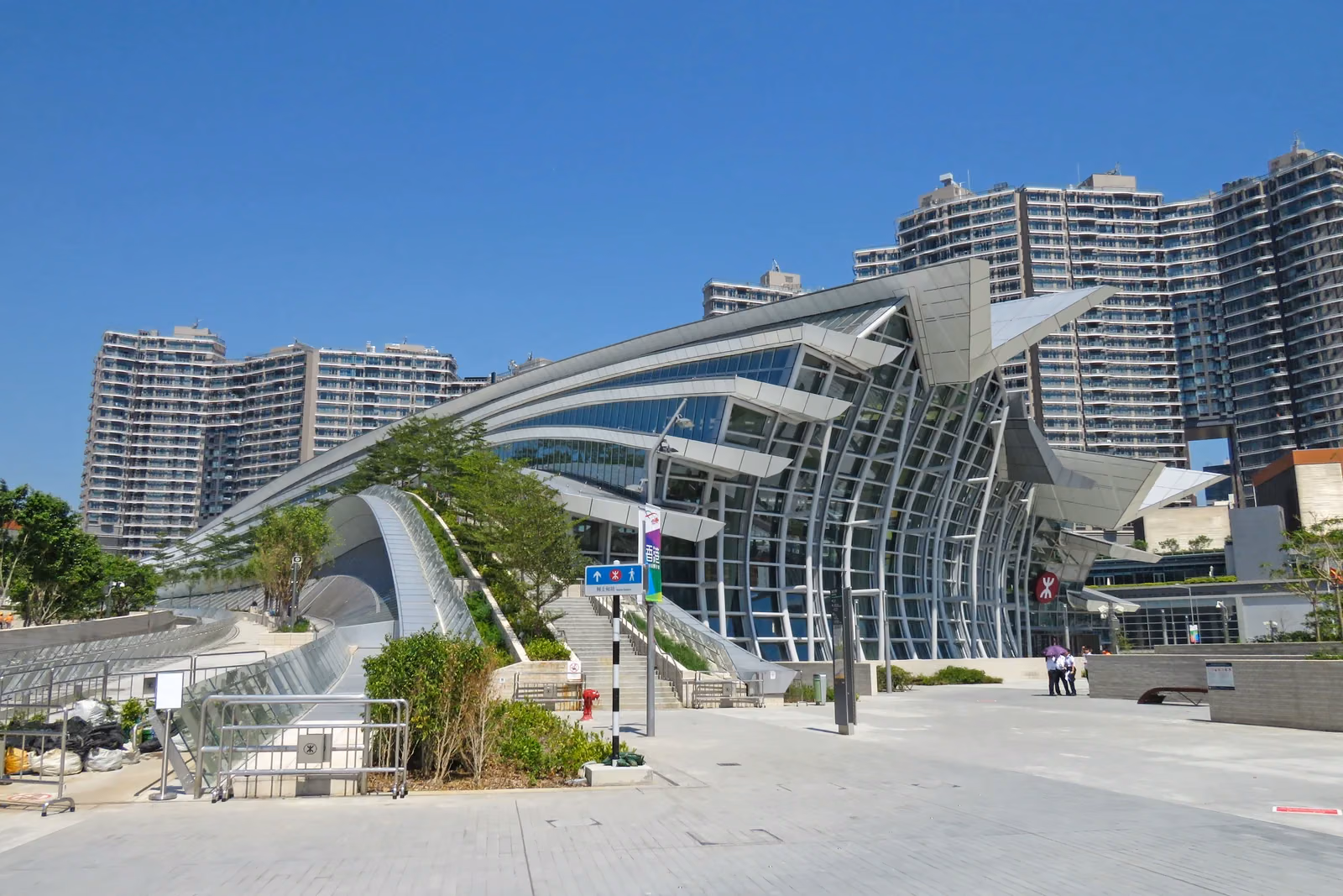 Curved glass facade and entrance plaza of Hong Kong West Kowloon railway station, photographed in October 2018